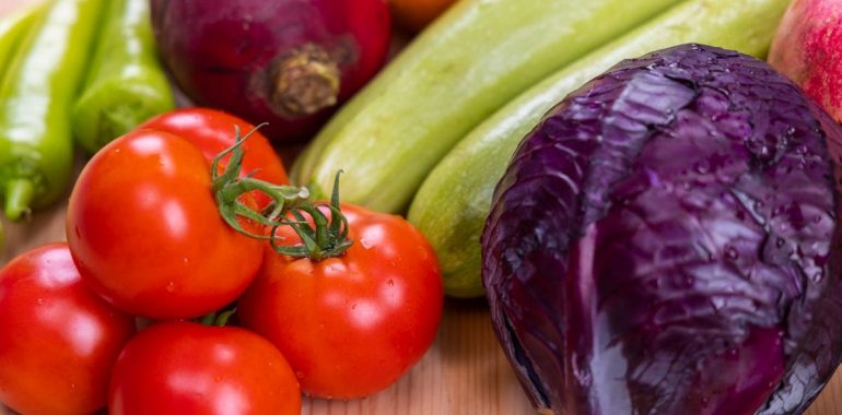 A vibrant assortment of fresh, organic vegetables on a wooden table, perfect for healthy eating.