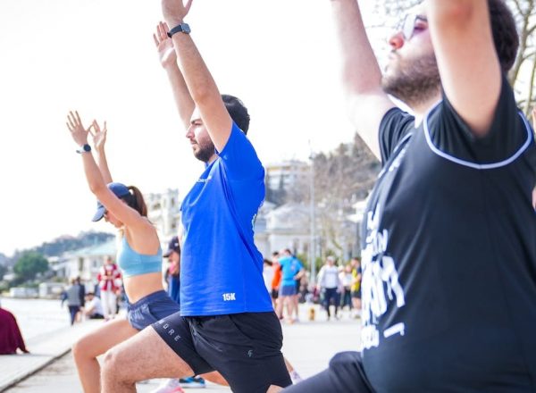 Group performing yoga outdoors along the scenic waterfront in İstanbul, Türkiye.