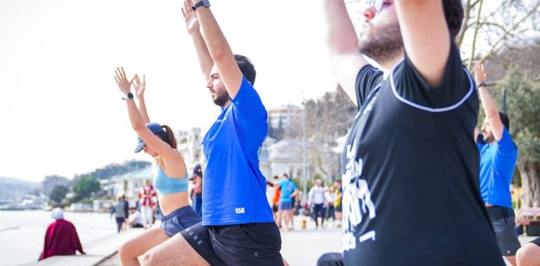 Group performing yoga outdoors along the scenic waterfront in İstanbul, Türkiye.